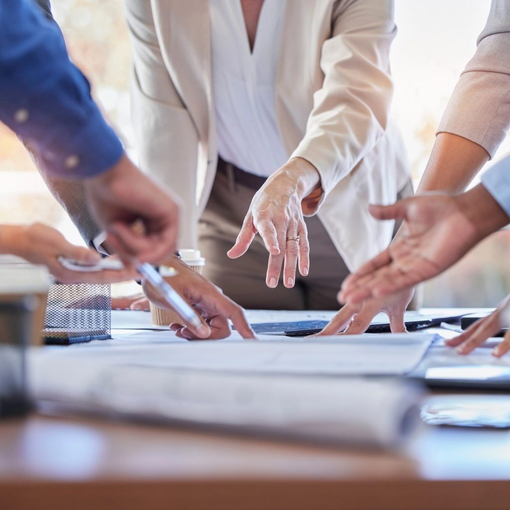 Riunione di lavoro: mani che indicano documenti su un tavolo